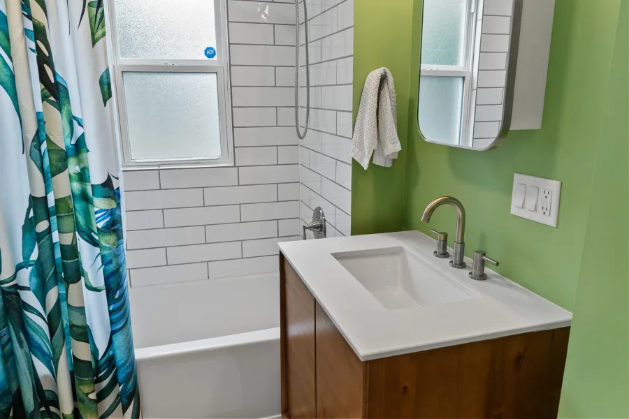 Full bathroom with double vanity, subway tile, and green accent wall — photographed by 513Shutter Cincinnati