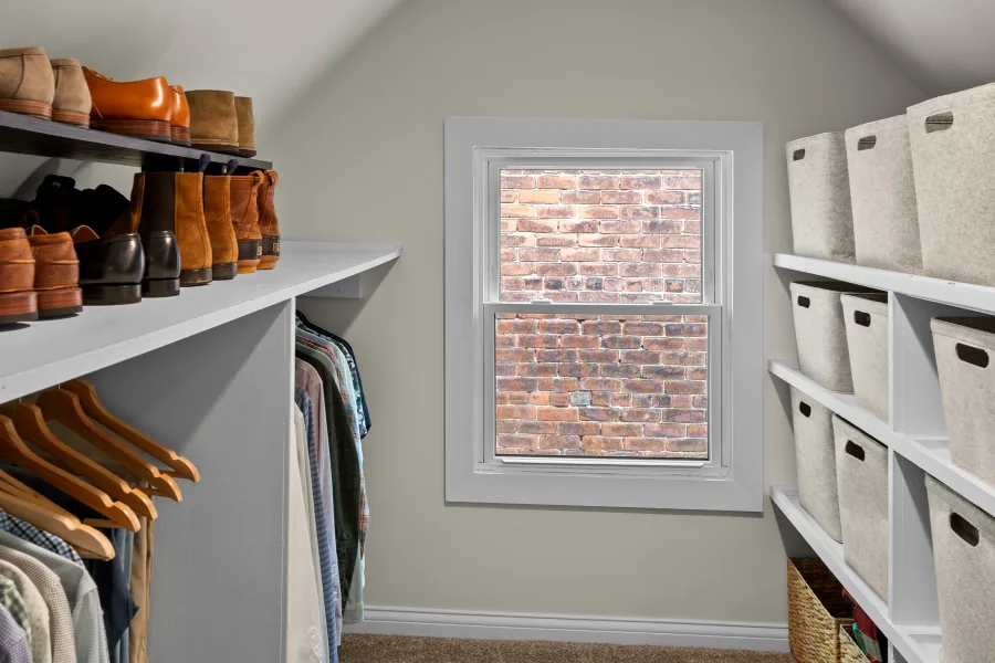 Walk-in closet with hanging storage, shelving, and exposed brick wall — photographed by 513Shutter Cincinnati