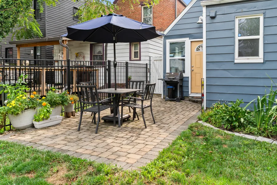 Paver patio with dining set and umbrella off the rear of the home — photographed by 513Shutter Cincinnati