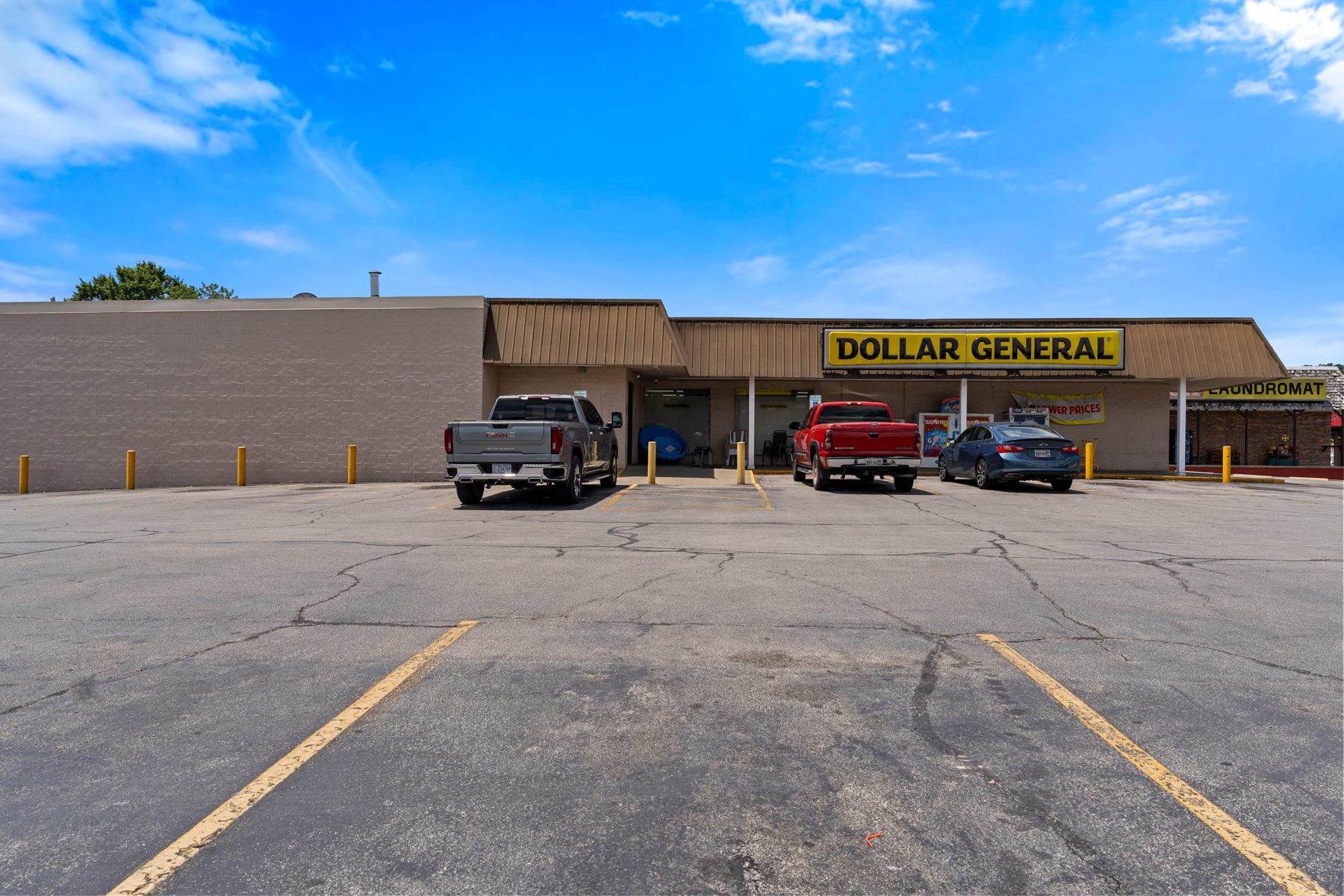 Angled exterior view of the Dollar General storefront with freestanding pylon sign