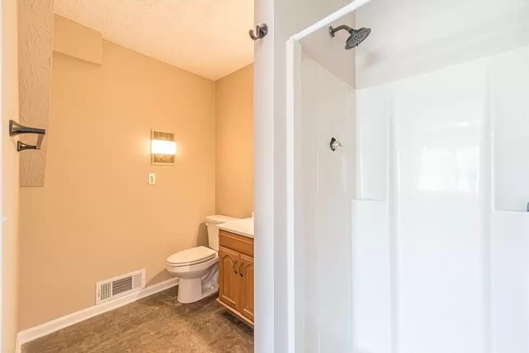 Bathroom with shower, toilet, vanity, and warm wall color