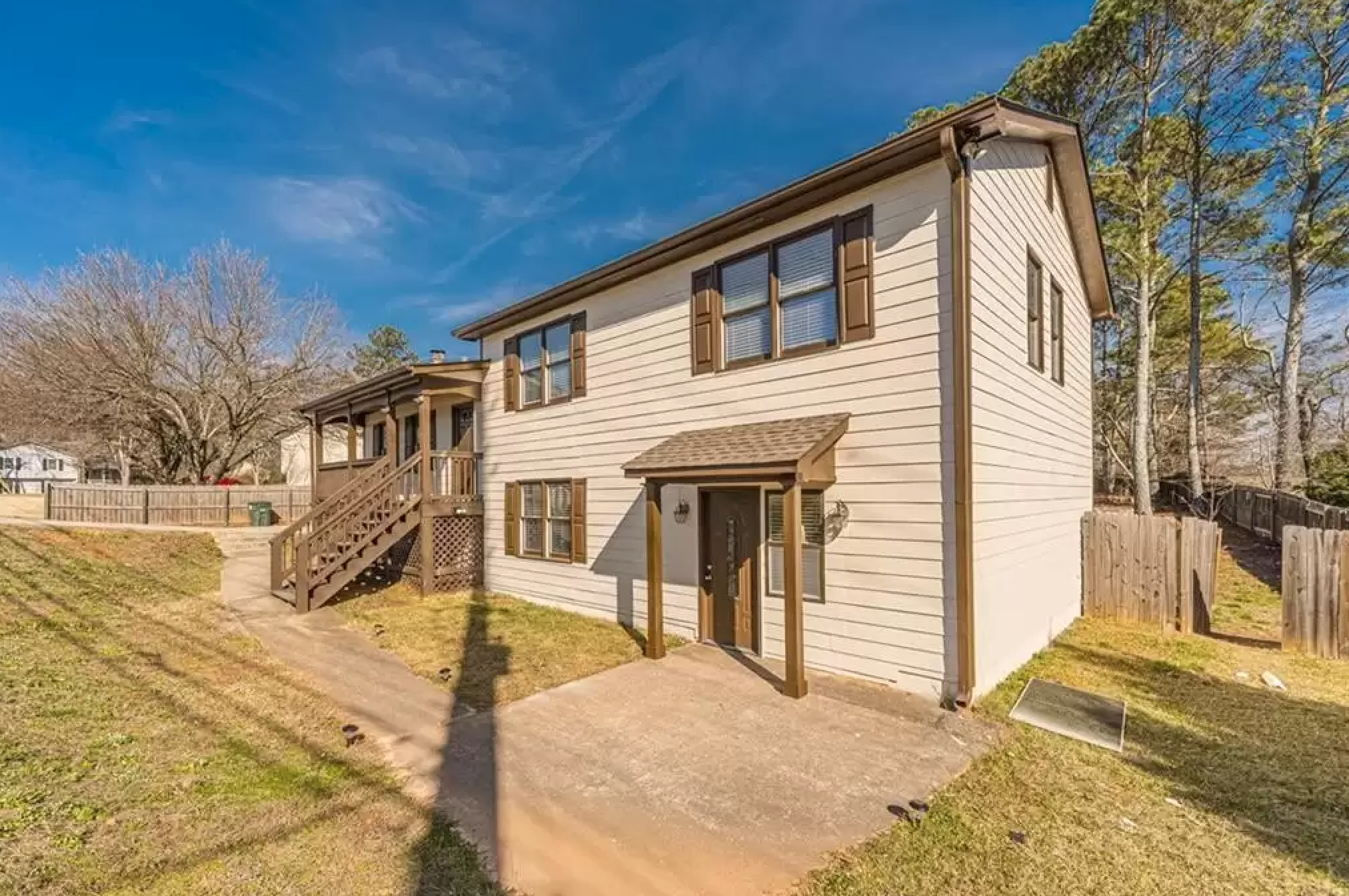 Alternate exterior angle showing the side of the property, stairs, and lower entry