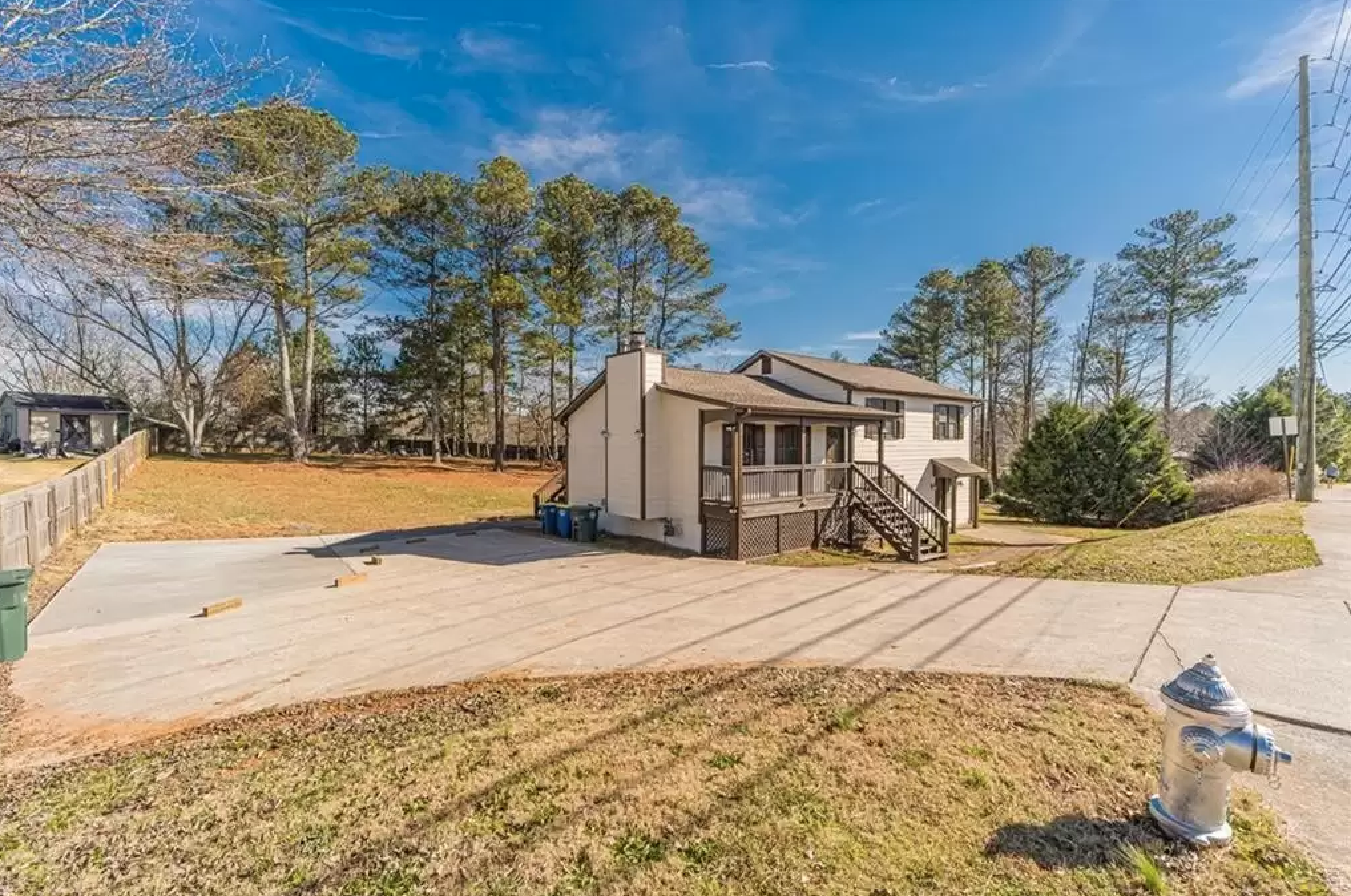 Streetview exterior photo showing driveway, side yard, and back porch of a split-level home