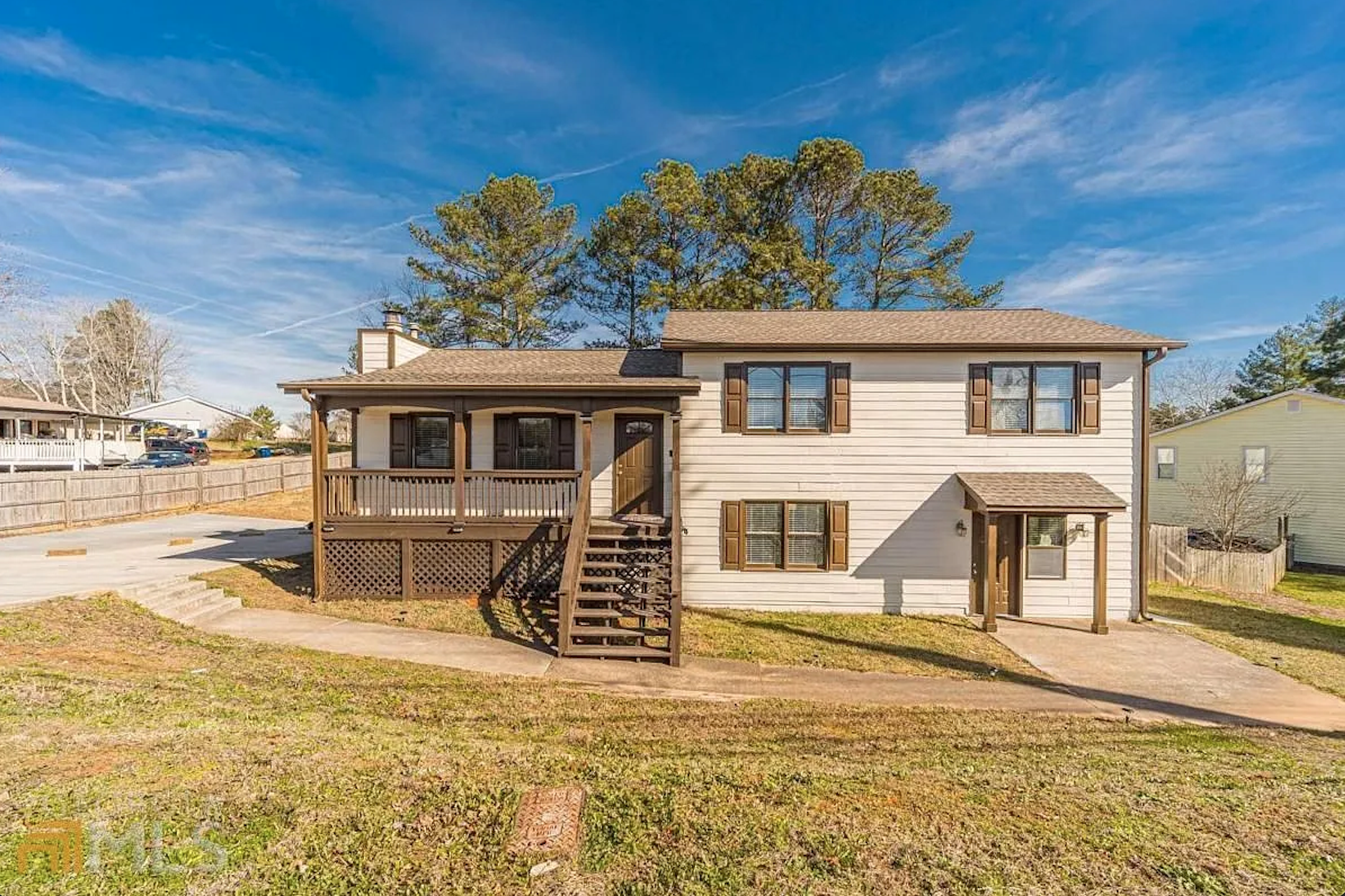 Front exterior real estate photo of a split-level property with porch and lower entry